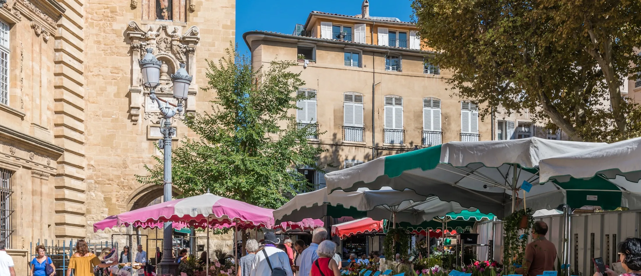 Place de marché animée avec parasols colorés et visiteurs