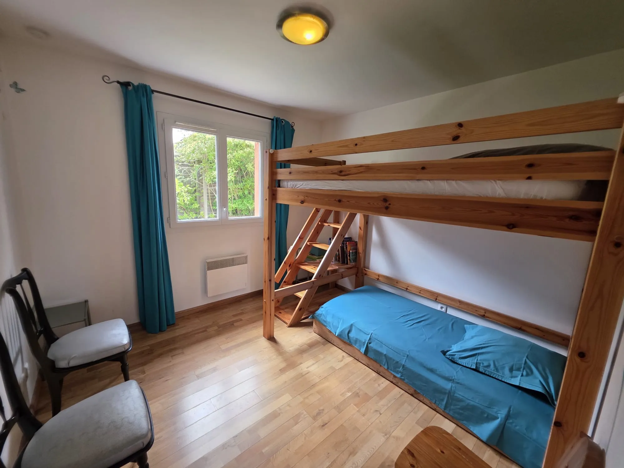 La chambre enfants avec lit mezzanine en bois et couchage au sol