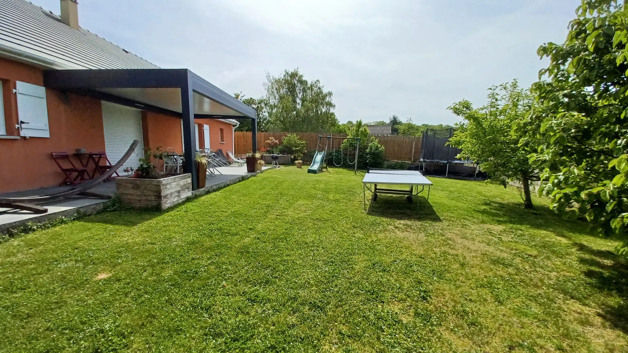 Le jardin avec table de ping-pong, balançoire et toboggan