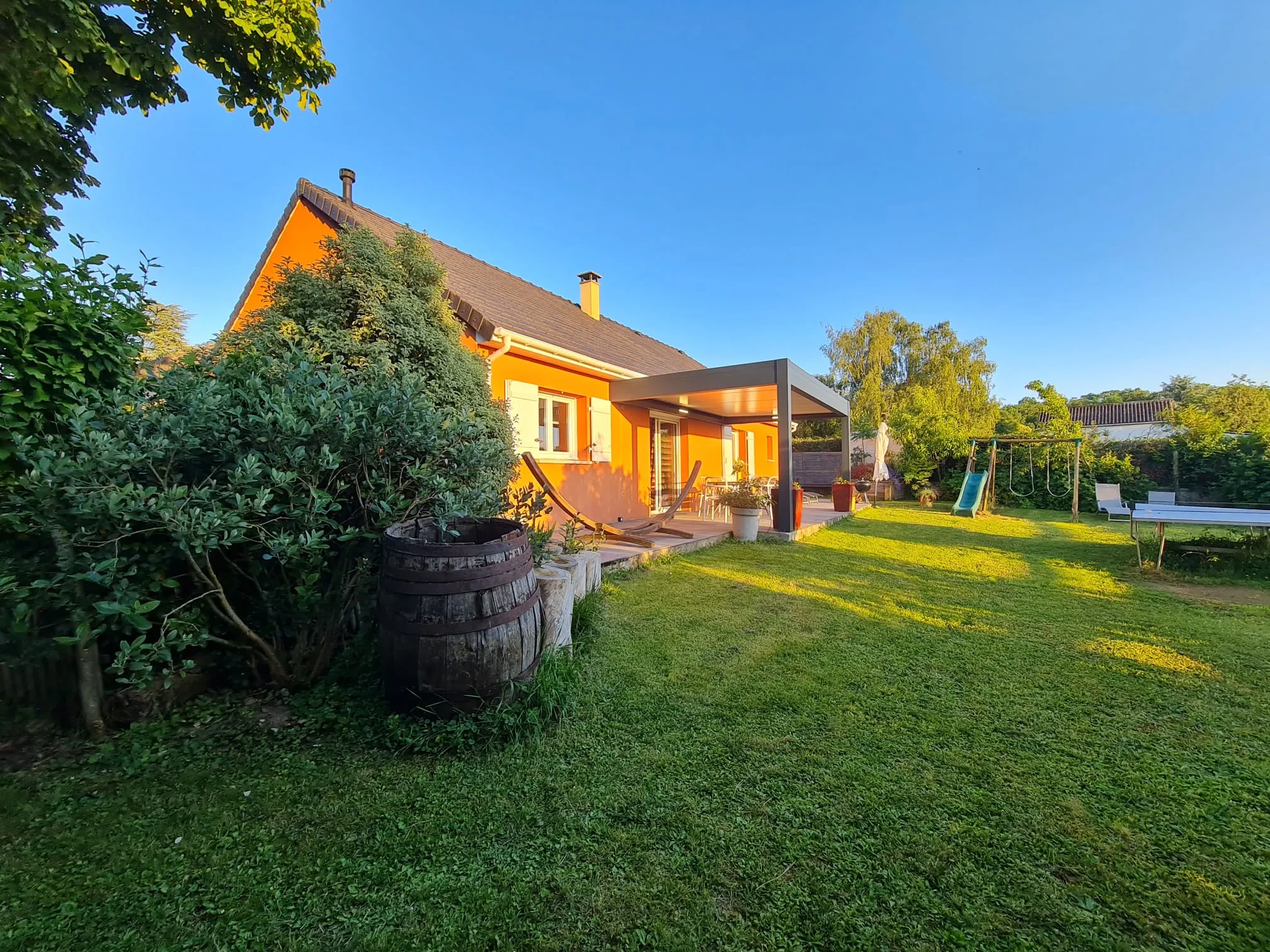 La maison vue du jardin, avec ses volets et son terrain clos