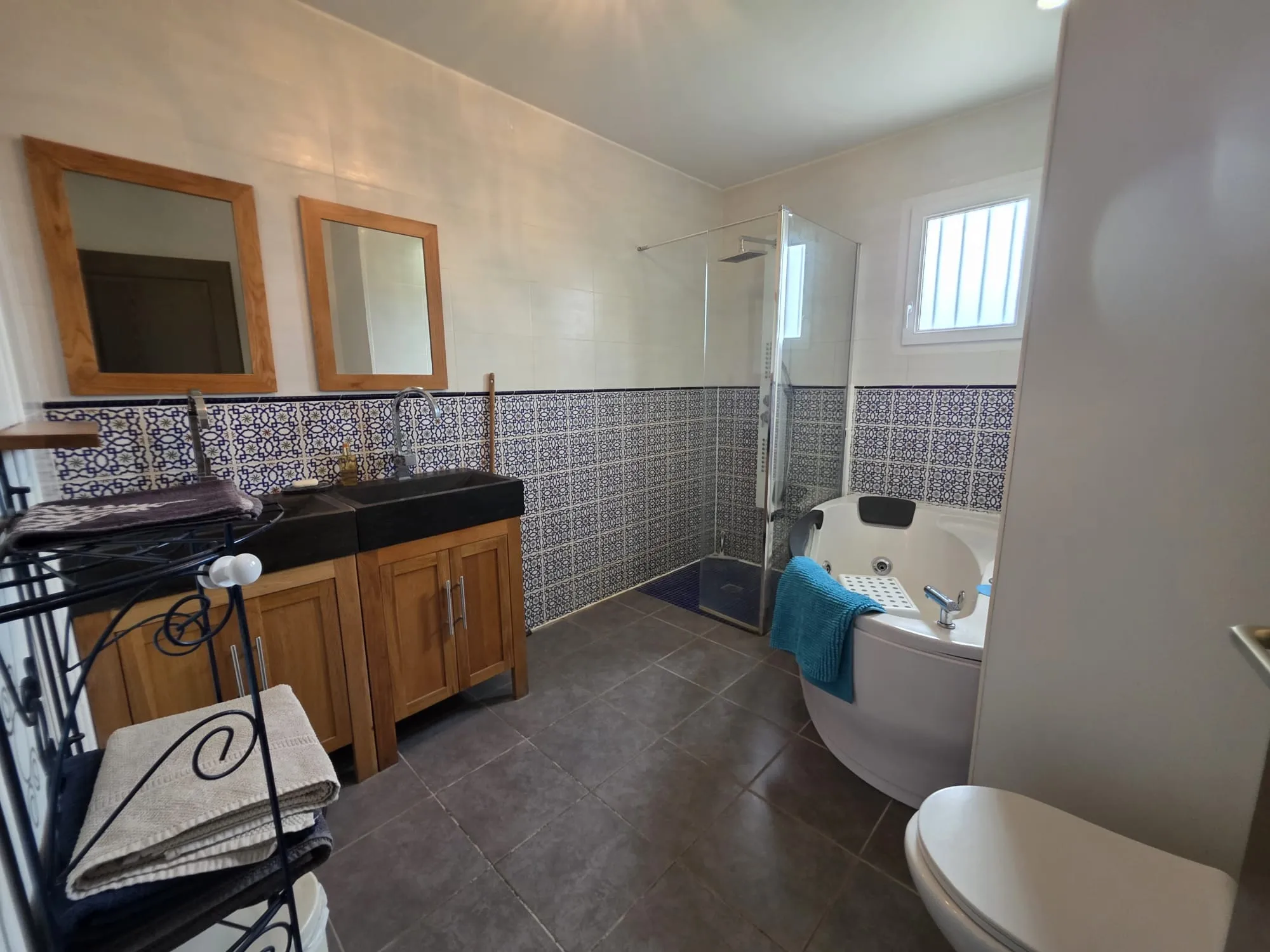 La salle de bains avec double vasque, douche et baignoire balnéo