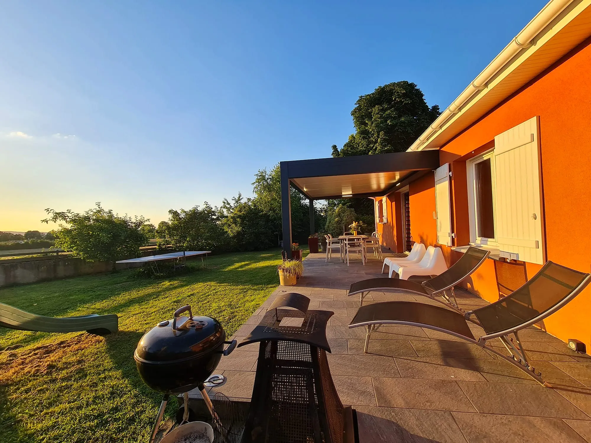 La terrasse du gîte au coucher du soleil, ouverte sur la campagne